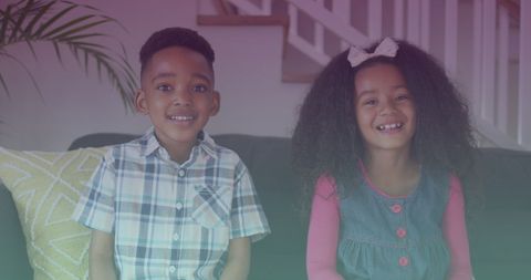 Joyful Siblings Sitting Together Smiling Indoors