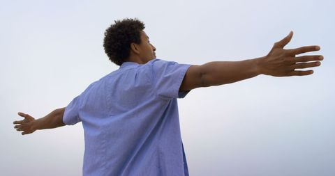 Joyful Man Embracing Ocean Breeze at Beach - Download Free Stock Images Pikwizard.com