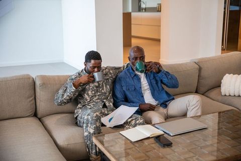 Father and Son Bond Over Coffee and Charts in Cozy Living Room