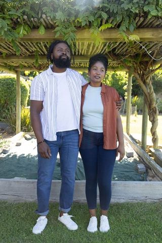 African american couple embracing under pergola near raised garden bed outdoor lifestyle
