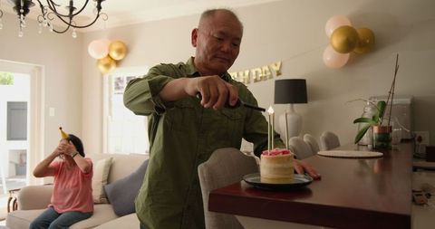 Senior man litig birthday cake surprising woman in living room