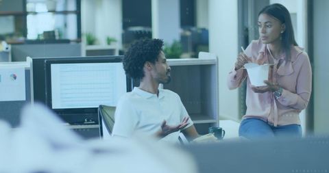 Professional Colleagues Engaged in Workplace Discussion at Modern Office