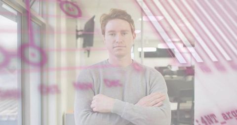 Young professional standing behind glass whiteboard with pink notes leading team brainstorming