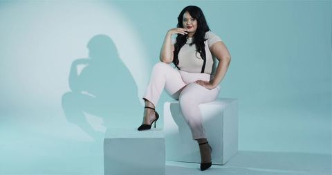 Confident woman in minimalist studio setting on modern block