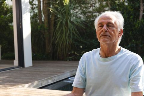 Senior Man Meditating Outdoor Beside Plunge Pool for Relaxation and Mindfulness