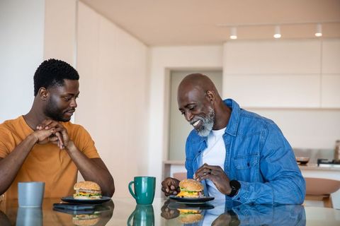 African American Father and Son Enjoying Meal Together in Modern Kitchen