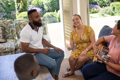 Relaxed Group Gathering in Sunroom with Lively Guitar Ambiance