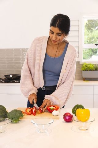 Woman Preparing Healthy Meal Chopping Vegetables in Modern Kitchen
