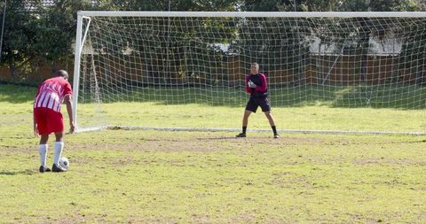 Intense penalty shootout on sunny soccer field