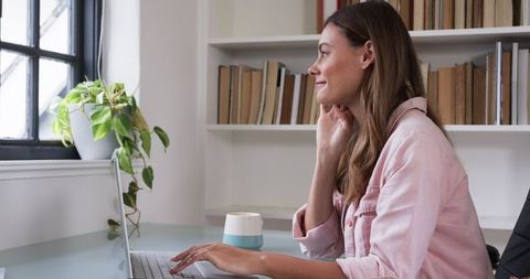 Woman Working on Laptop in Bright Home Office