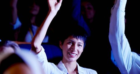Young Businesswoman Engaged in Seminar Raising Hand with Smile