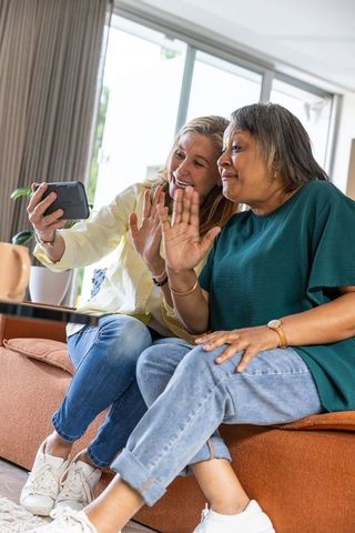 Diverse Female Friends Video Calling on Sofa
