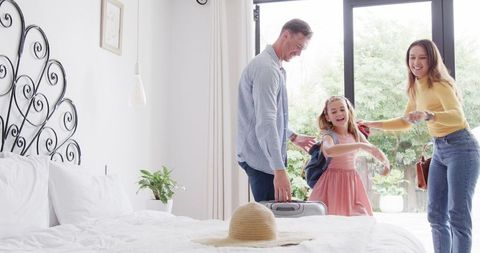 Family Preparing to Leave for Vacation in Bright Modern Bedroom