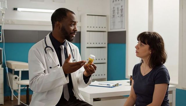 Doctor explaining prescription medication to patient during medical consultation in clinic