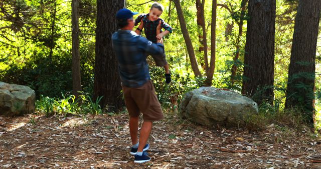 Father lifting young son in forest clearing during bright afternoon - Download Free Stock Images Pikwizard.com