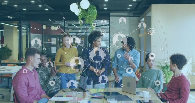 Young professionals gathered around a workspace, engaging in collaborative discussion. Digital network overlay signifies technological advancement and connectivity. Ideal for use in contexts highlighting teamwork, modern office environments, and innovation within startups.