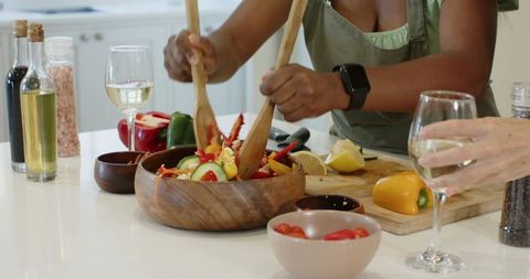 Women Preparing Fresh Salad and Enjoying Wine in Rustic Kitchen