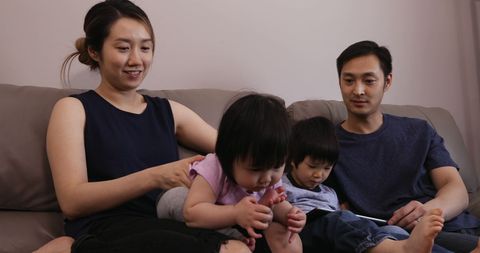 Asian Family Bonding on Sofa with Young Children
