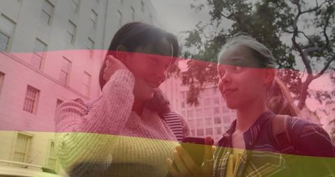 Teenage friends using smartphone on city sidewalk