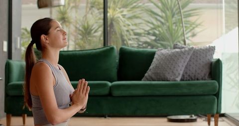 Woman Practicing Yoga Prayer Pose at Home in Tranquil Living Room