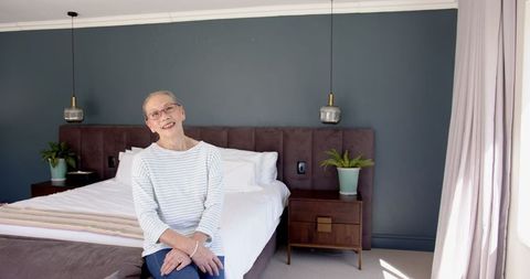 Senior Woman Relaxing on Modern Bedroom Bed
