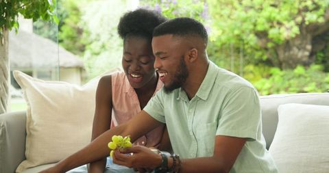 Couple Enjoying Sweet Moment Sharing Dessert Together on Sofa