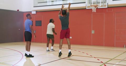 African american men playing indoor basketball practicing shooting passing and rebounding