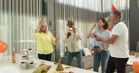 Diverse colleagues celebrating lively office party with sparklers