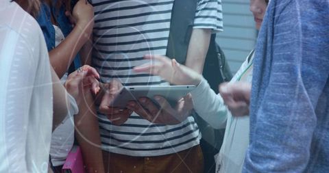 Young adults collaborating on tablet with augmented reality hud overlay in casual interior
