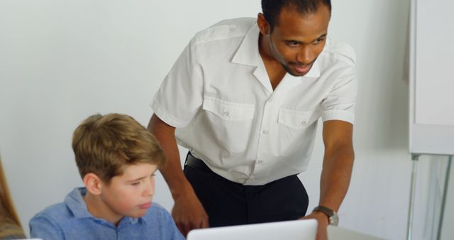 Teacher Assisting Young Student on Laptop in Classroom - Download Free Stock Images Pikwizard.com