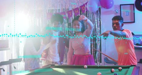 Group of friends celebrating birthday around neon pool table with disco decorations