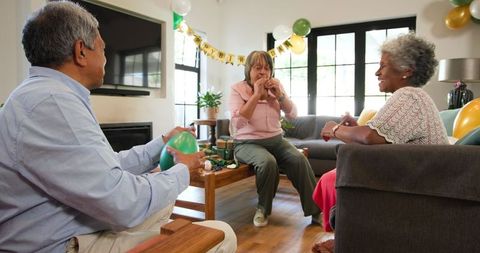 Happy Seniors Enjoying Birthday Celebration With Balloons
