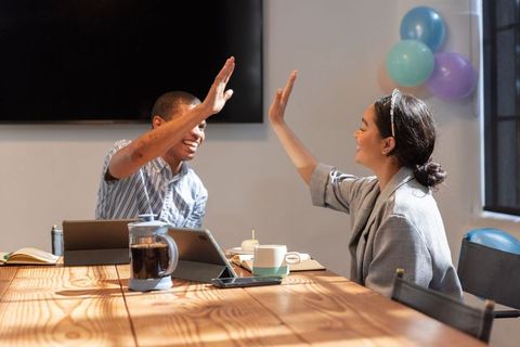Diverse Coworkers Celebrating Success with High-Five in Office