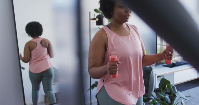 Woman Exercising at Home in Front of Mirror with Dumbbells - Download Free Stock Images Pikwizard.com