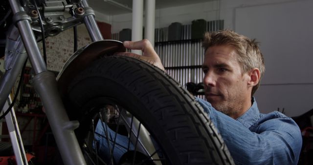 Mechanic Repairing Motorcycle Front Wheel in Workshop - Download Free Stock Images Pikwizard.com