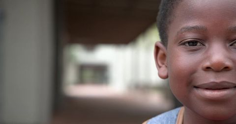 Close-up of a child in overalls in urban school corridor
