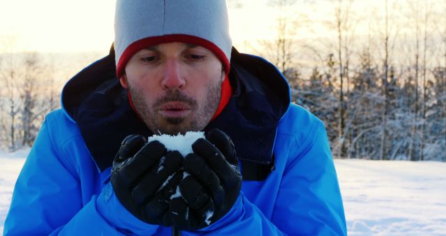 Man Blowing Snow in Winter Landscape Wearing Blue Jacket - Download Free Stock Images Pikwizard.com