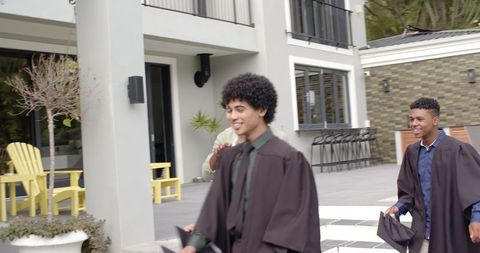 Diverse graduates celebrating with family outdoors