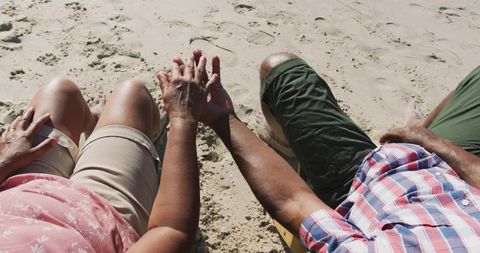 Mature Couple Holding Hands on Sunny Beach Midday Tranquility