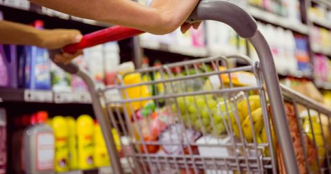 Woman Shopping for Groceries with Full Cart in Supermarket - Download Free Stock Images Pikwizard.com