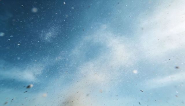 Drifting blue sky showing sunlit dust particles, wispy clouds and soft hazy atmosphere