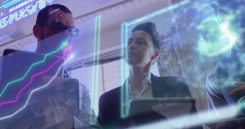 Business team analyzing digital charts with modern technology