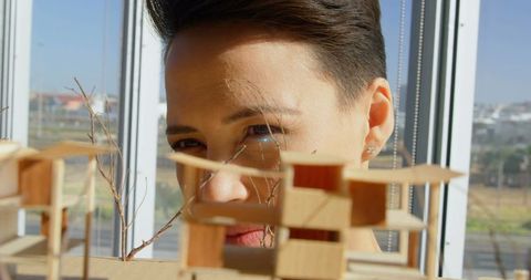 Architect Analyzing Innovative Scale Model in Bright Space