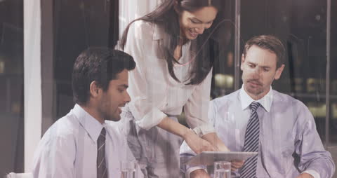 Diverse Team Analyzing Financial Data on Tablet in Office Meeting