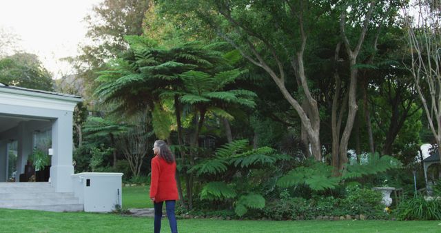 Woman Walking in Lush Green Garden near Modern House - Download Free Stock Images Pikwizard.com