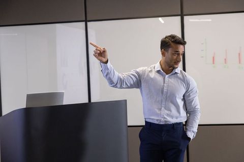 Business professional presenting bar chart in modern office