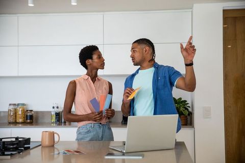 Couple Discussing Color Choices in Modern Kitchen Interior Design