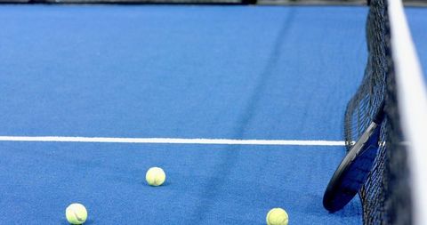 Tennis racket and balls arrangement on blue hard court