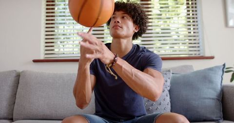 Young Man Spinning Basketball at Home in Relaxing Surroundings