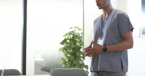 African american nurse speaking and gesturing during healthcare team meeting in clinic